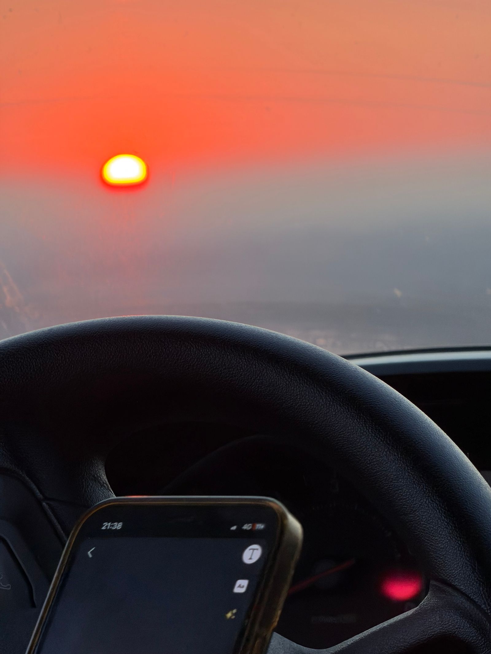Coucher de soleil flamboyant vu à travers le pare-brise pendant un road trip