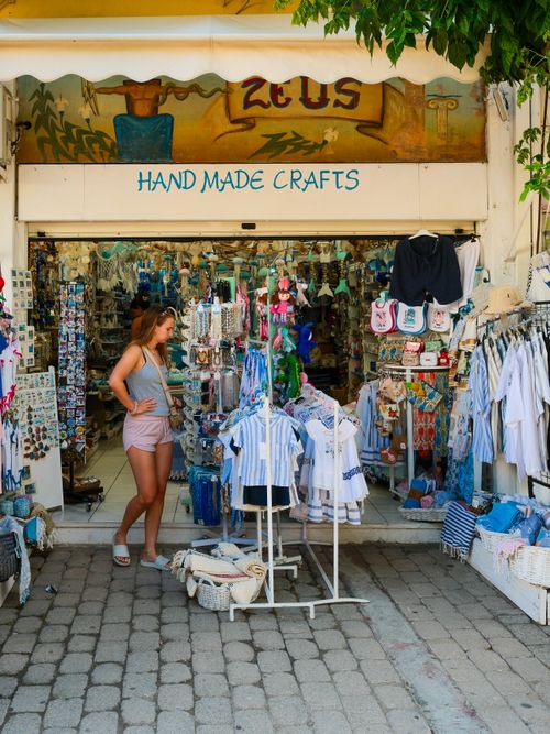 Free A woman browsing a handmade crafts store in Skiathos, Greece, vibrant and colorful display. Stock Photo