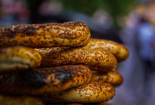 Free Appetizing close-up of stacked freshly baked sesame seed bagels in soft focus background. Stock Photo