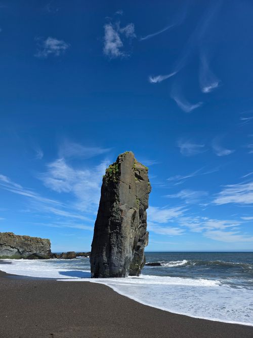 Free Striking monolith on a black sand beach in Iceland under a clear blue sky. Stock Photo
