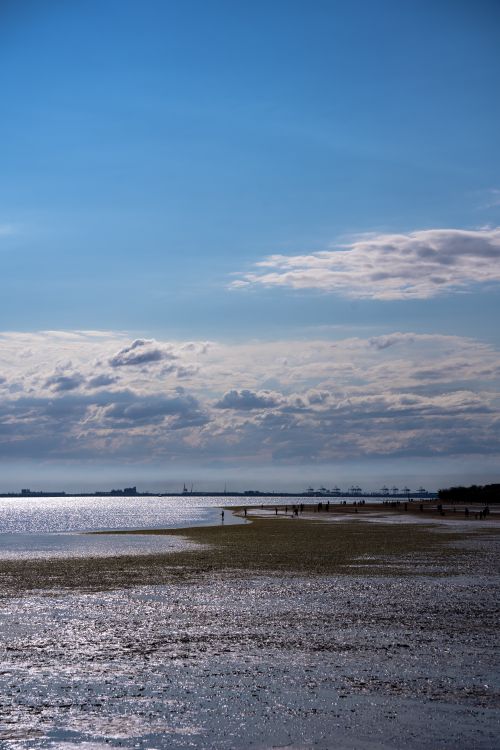 Free A beautiful coastal landscape with dramatic clouds over a calm beach, perfect for relaxation and travel themes. Stock Photo