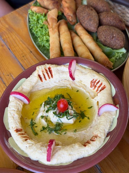 Free A vibrant Lebanese mezze platter featuring creamy hummus, kibbeh, and spring rolls, perfect for sharing. Stock Photo