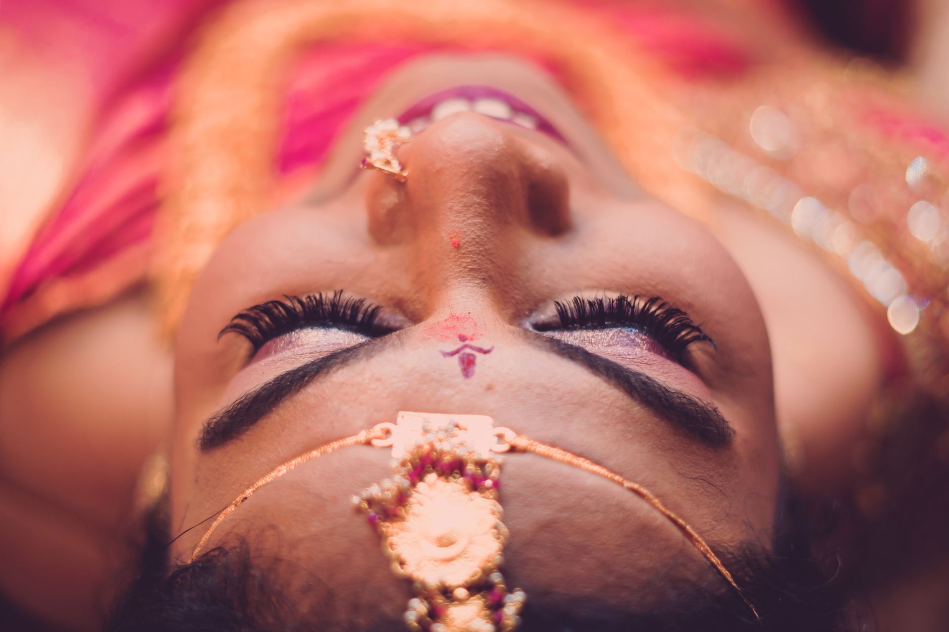 Detailed close-up of a bride with traditional bridal makeup and jewelry, showcasing intricate details and cultural elegance.