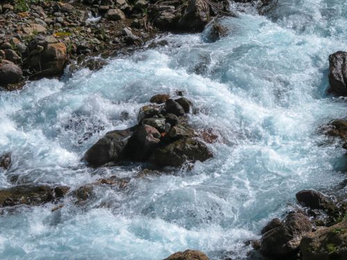 Free Dynamic view of a rushing mountain stream with clear, vibrant water and rugged rocks. Stock Photo