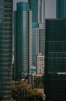 A dramatic view of towering skyscrapers in a bustling cityscape.