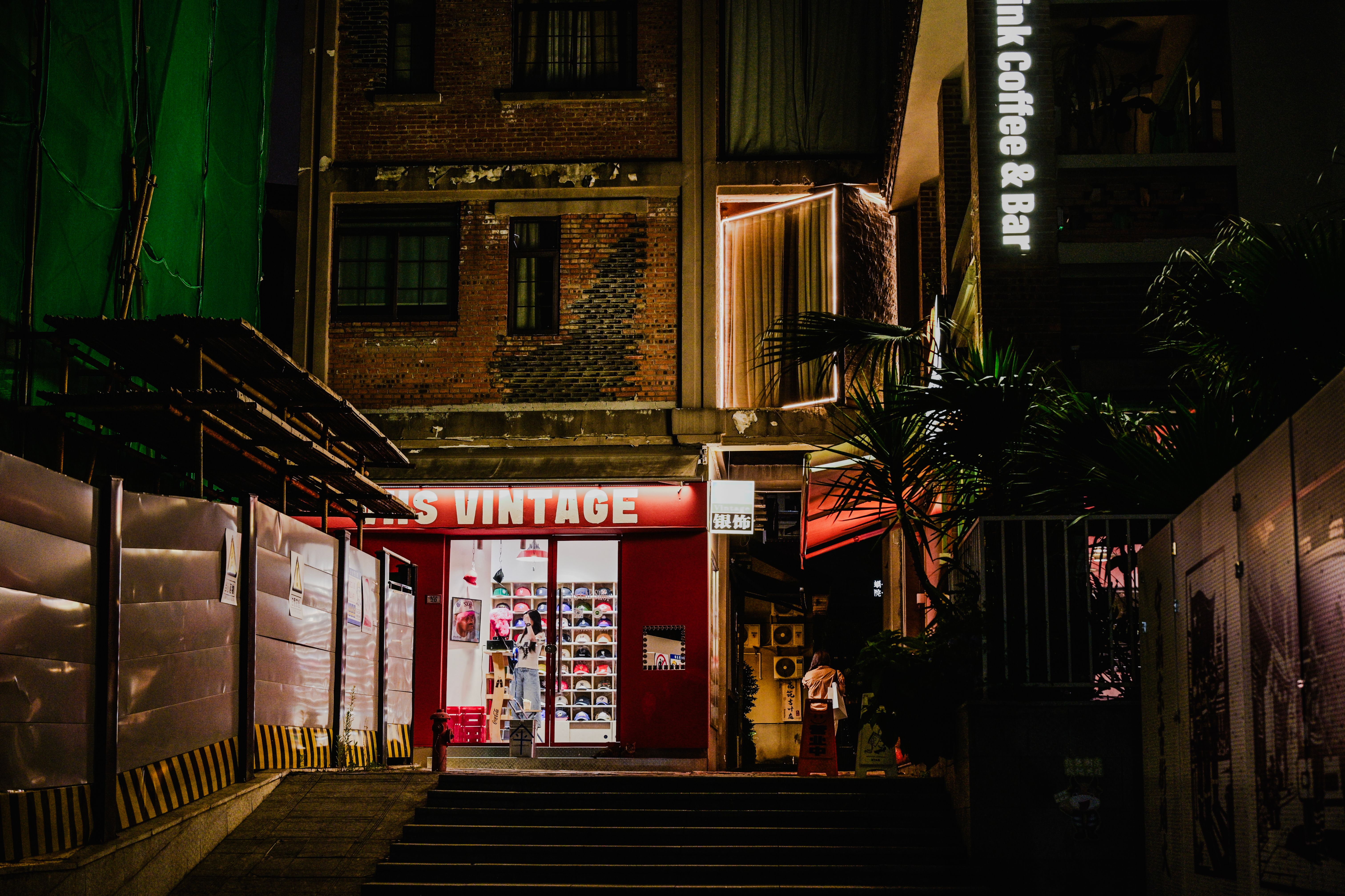 夜にライトアップされた、趣のあるヴィンテージショップの入り口を写した、街並みの一コマ。