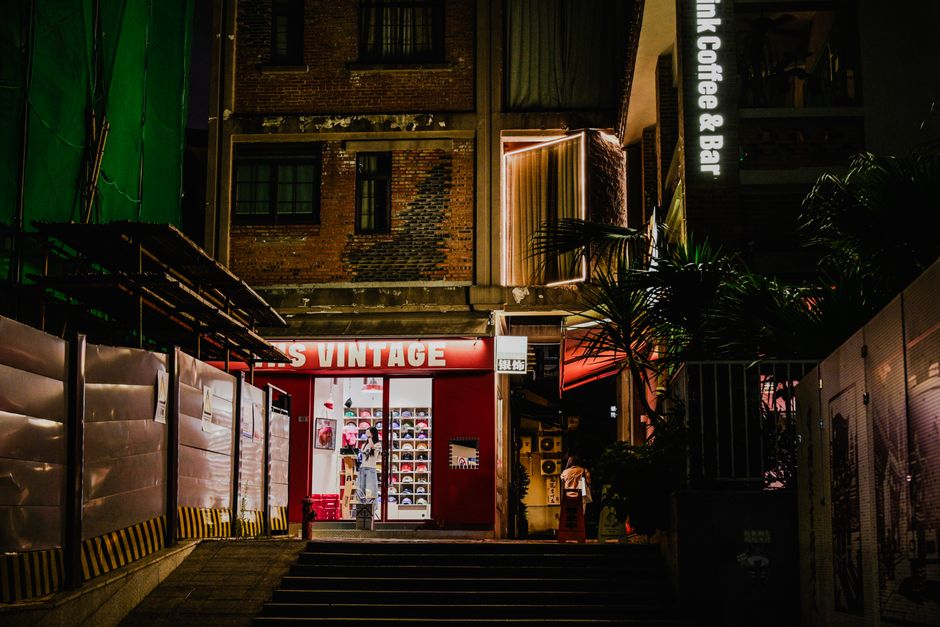 夜にライトアップされた、趣のあるヴィンテージショップの入り口を写した、街並みの一コマ。