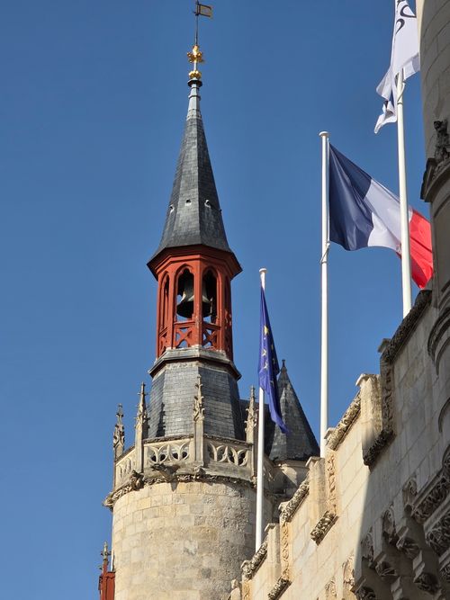 Free A stunning view of a historic tower in La Rochelle, France, with flags against a clear blue sky. Stock Photo