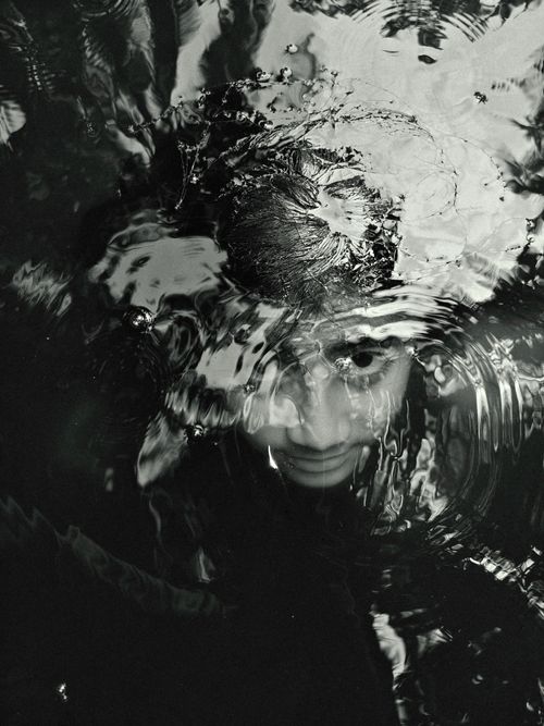 Free Artistic black and white image of a face submerged and distorted by water ripples. Stock Photo