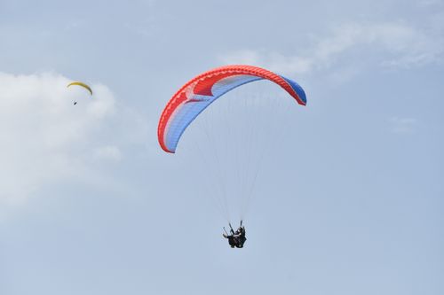 Free Exciting paragliding experience in Bir, soaring high above with clear blue skies. Stock Photo