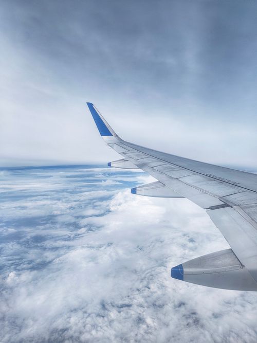 Free Stunning view of airplane wing flying above fluffy clouds in bright sky. Stock Photo