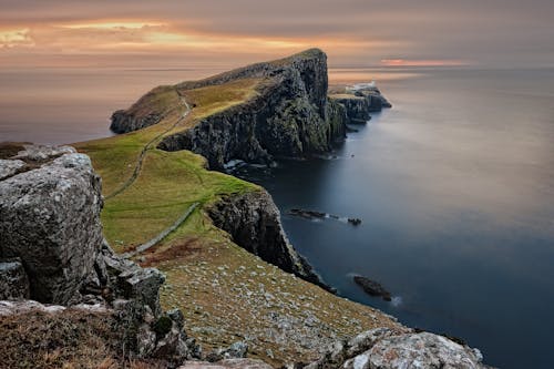 Green and Brown Mountain Cliffs Near Ocean