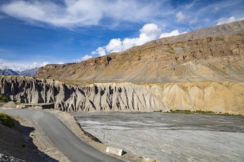 Free Serene mountain road winding through a rugged canyon under a bright blue sky, offering breathtaking views. Stock Photo