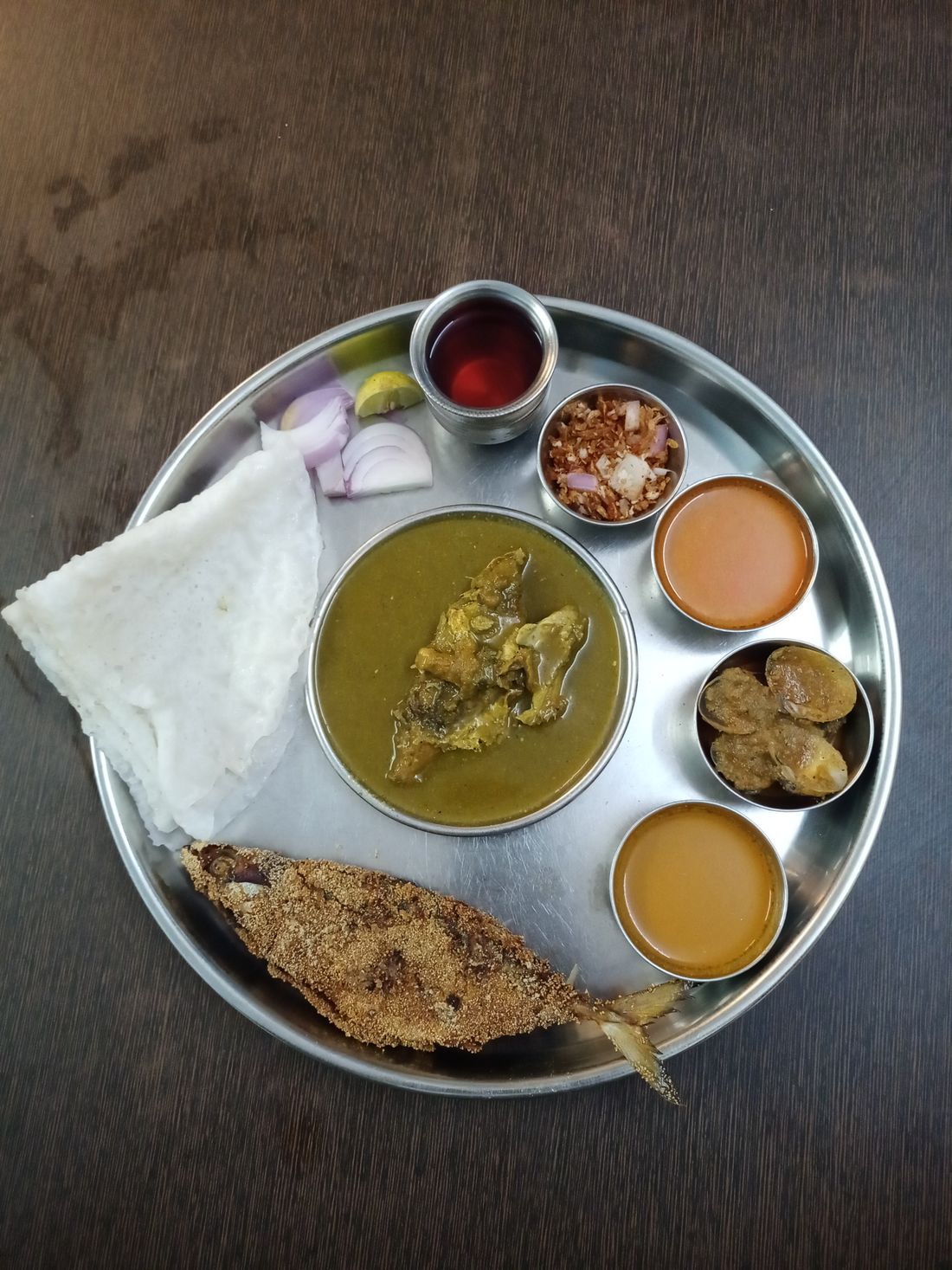 Steel thali with katoris serving fish curry and rice
