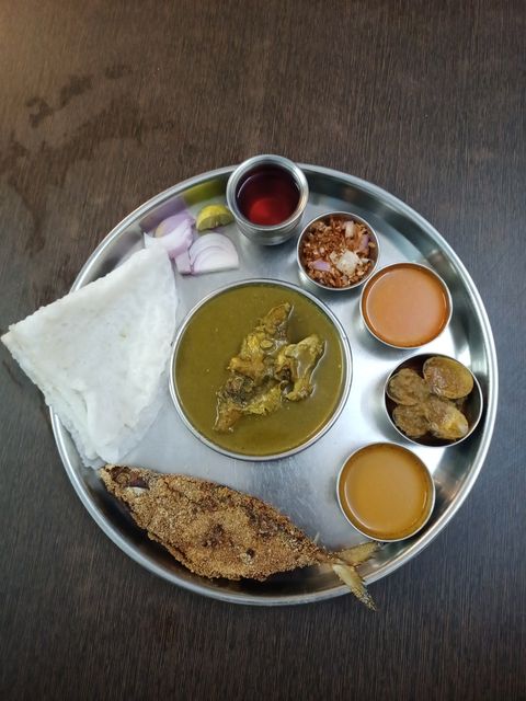 Steel thali with katoris serving fish curry and rice