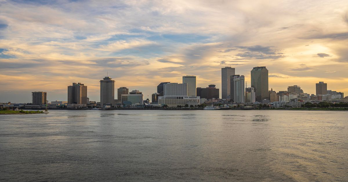 Beautiful skyline of New Orleans across the Mississippi River during sunset.