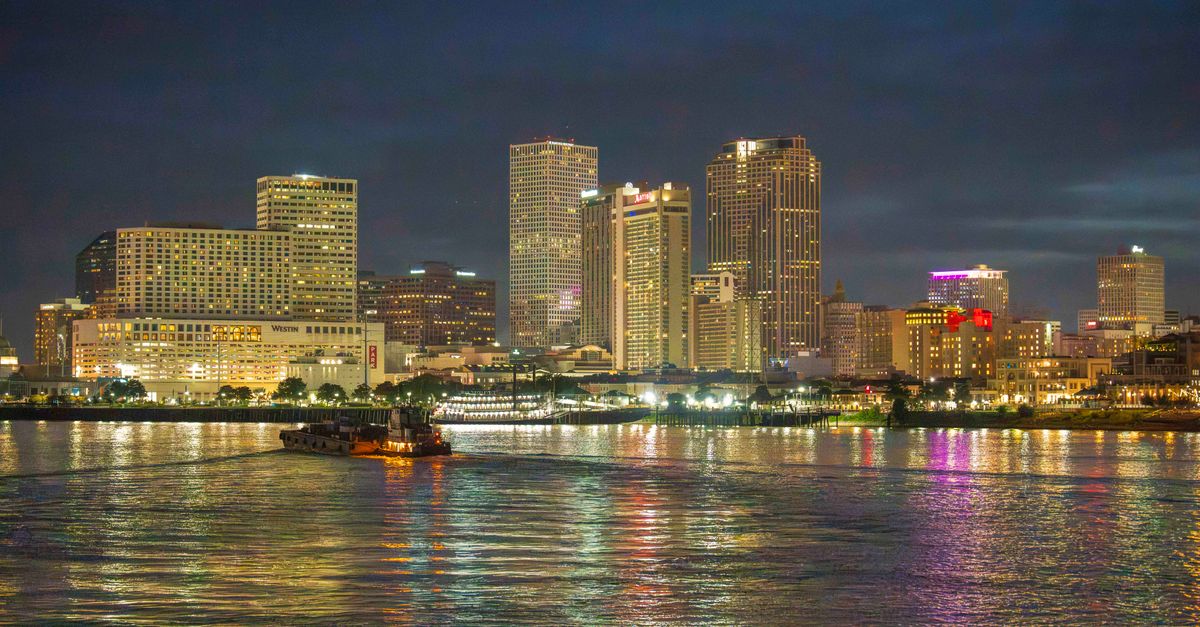 A breathtaking night skyline view of New Orleans with vibrant reflections on the Mississippi River.