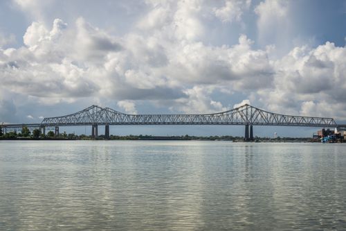 Free Scenic view of the Crescent City Connection with clouds over the Mississippi River in a tranquil setting. Stock Photo