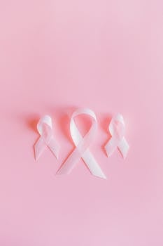Photo by Anna Shvets Three pink ribbons symbolize breast cancer awareness on a light pink background.