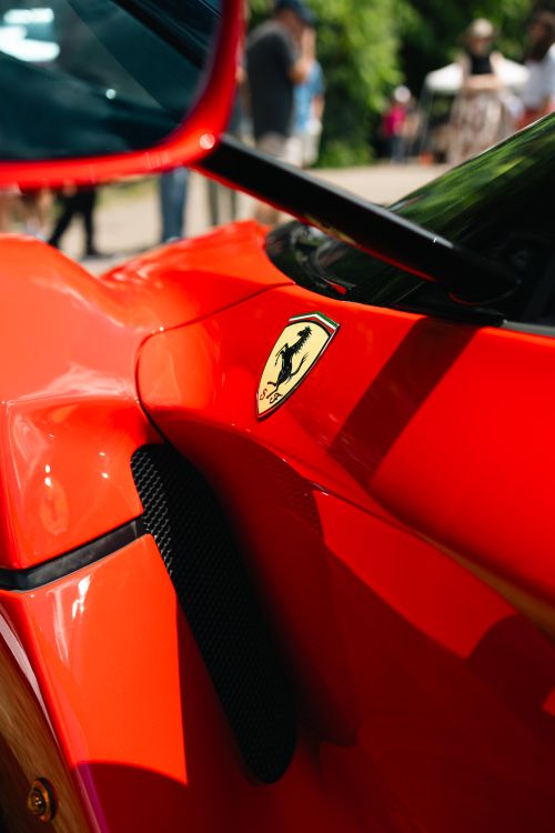 Free Red sports car with visually striking iconic logo, captured outdoors during the day. Stock Photo