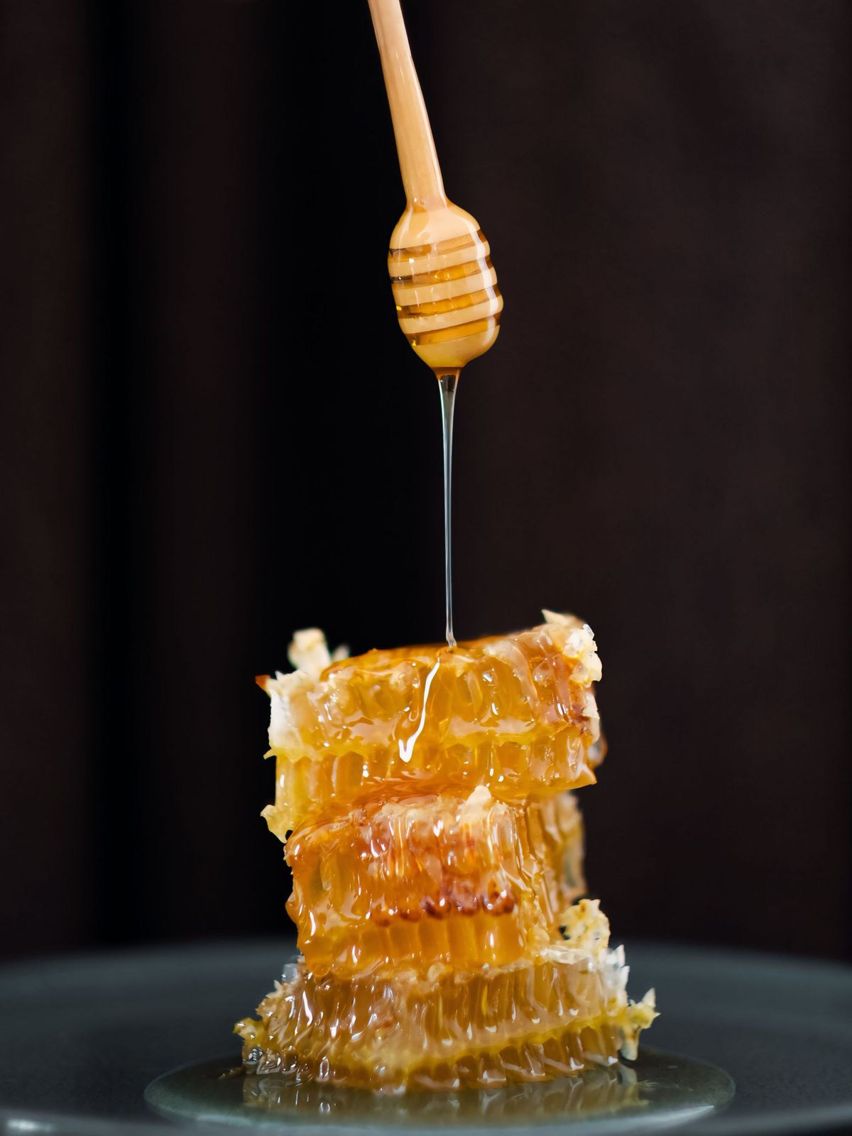Stacked honeycomb dripping raw honey — photo by Özge Arsoy on Pexels