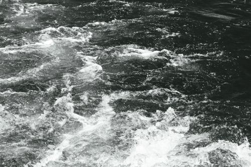Free Abstract black and white photo capturing dynamic water movement with ripples and splash. Stock Photo