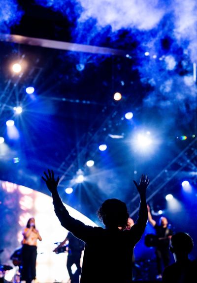 Crowd silhouettes under blue stage beams, photo by Caleb Oquendo on Pexels