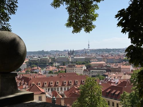 Free A breathtaking view of Prague's iconic red rooftops and skyline under a clear blue sky. Stock Photo