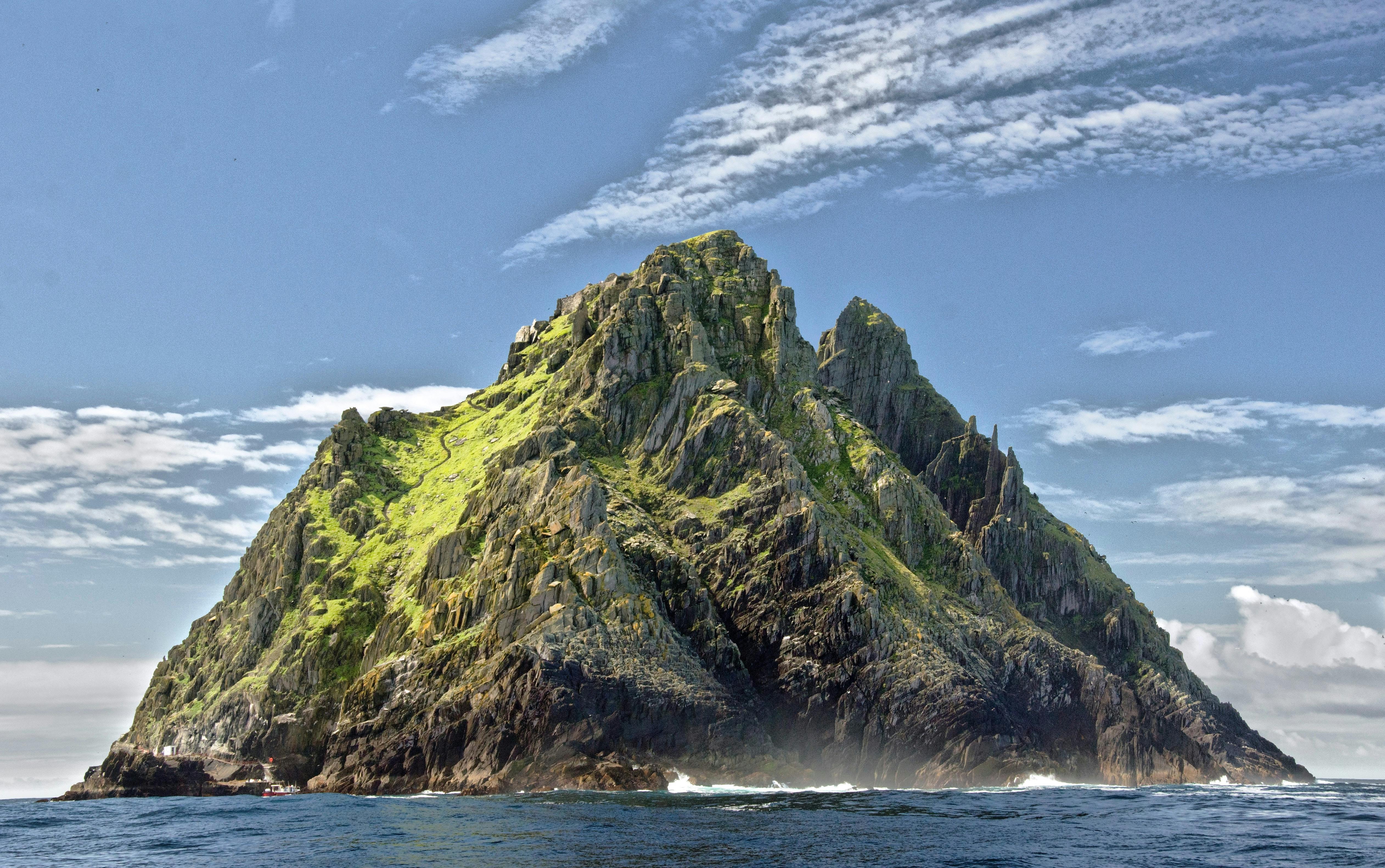 Green And Brown Mountain In The Middle Of The Ocean