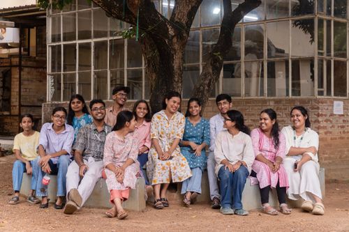 Free A group of college students smile and relax under a tree at a campus in Santiniketan, India. Stock Photo