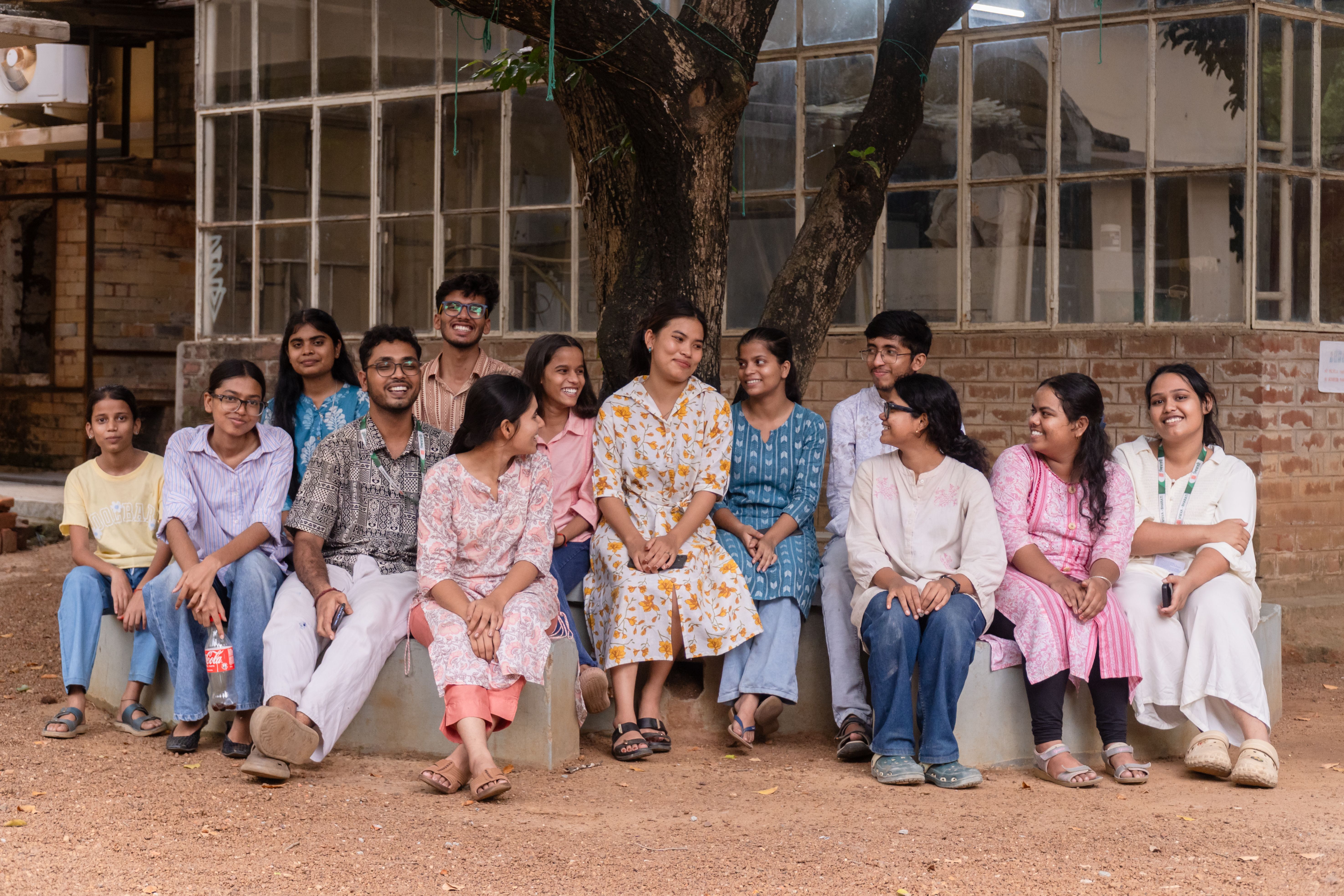 A group of South Asian college students enjoying a relaxed moment under a tree at Santiniketan campus.