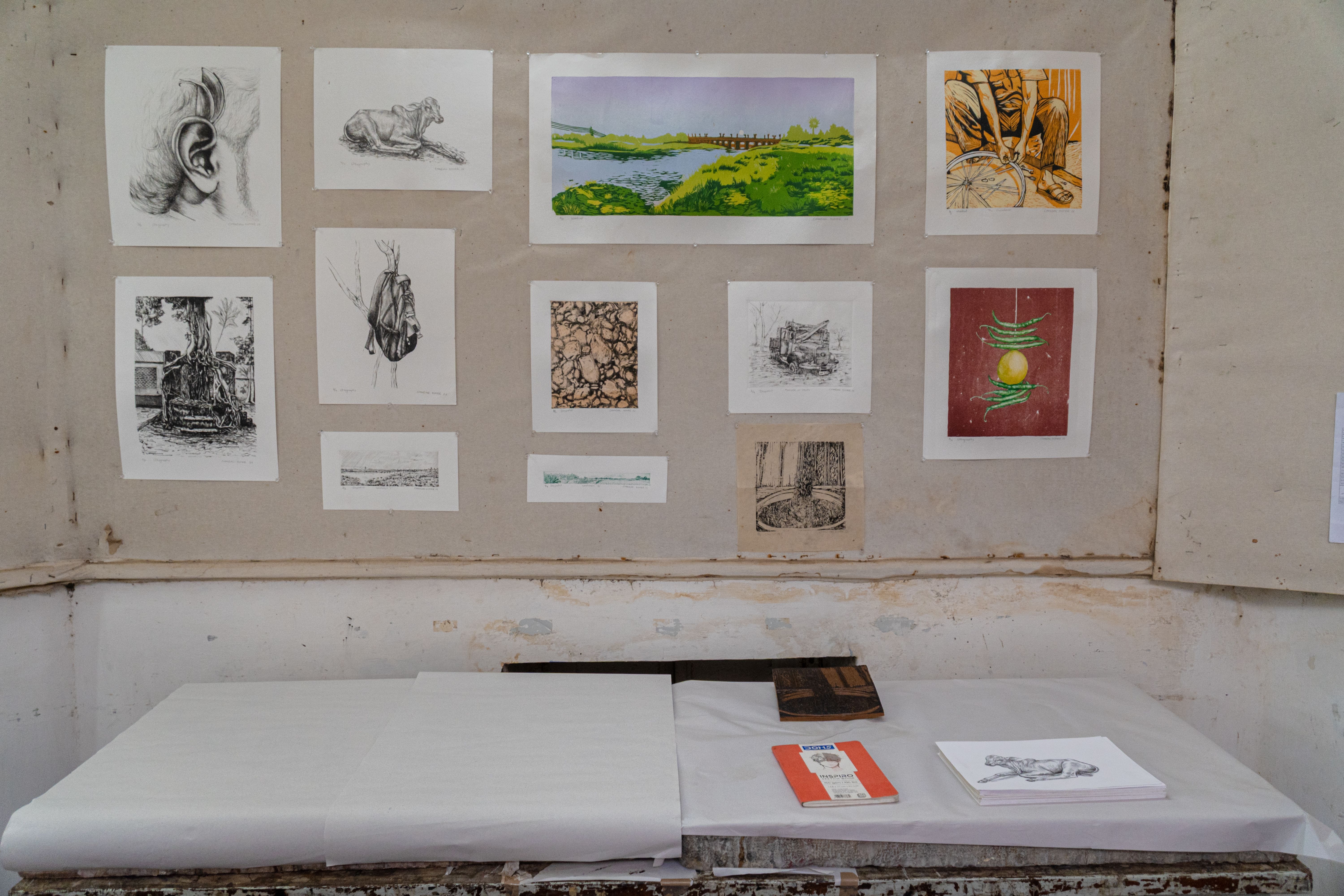 A diverse collection of art and sketches displayed in a Santiniketan studio.