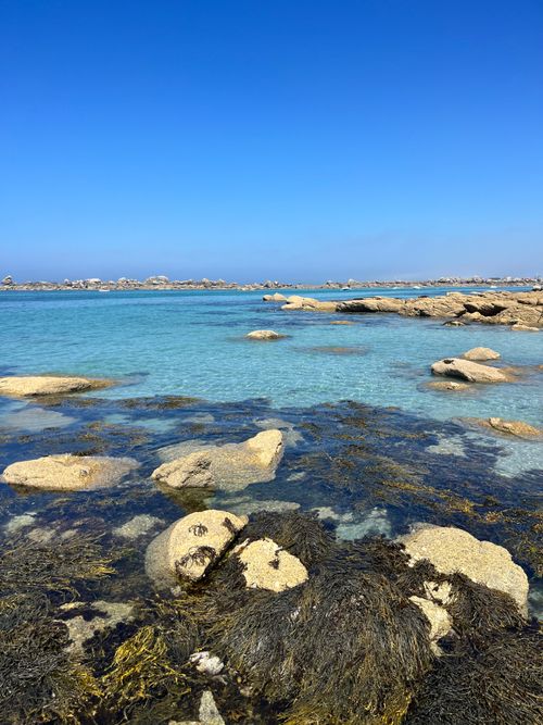 Free Vibrant blue sea and rocky coastline under a clear sky in Kerlouan, Bretagne, France. Stock Photo