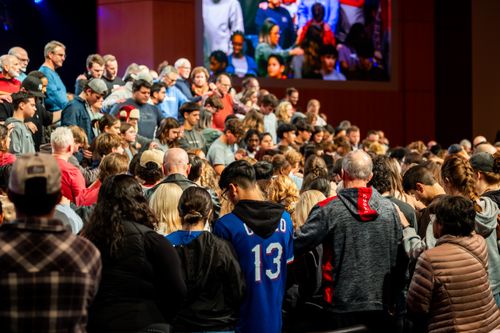 Free A diverse crowd gathers indoors for a communal event, displaying unity. Stock Photo