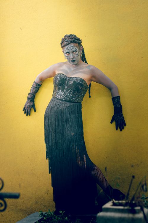 Free Artistic gothic cosplay with makeup and black dress on a vivid yellow backdrop in Mexico City. Stock Photo