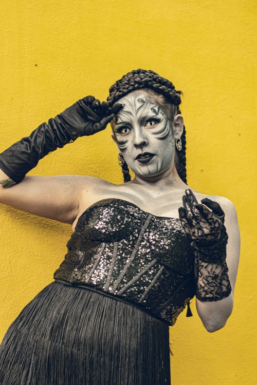 Free A creative gothic-inspired cosplay portrait featuring artistic makeup against a vibrant yellow background. Stock Photo