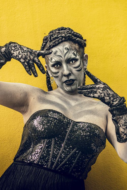 Free A striking cosplay portrait featuring a character with artistic makeup and a sequined corset against a vivid yellow background. Stock Photo