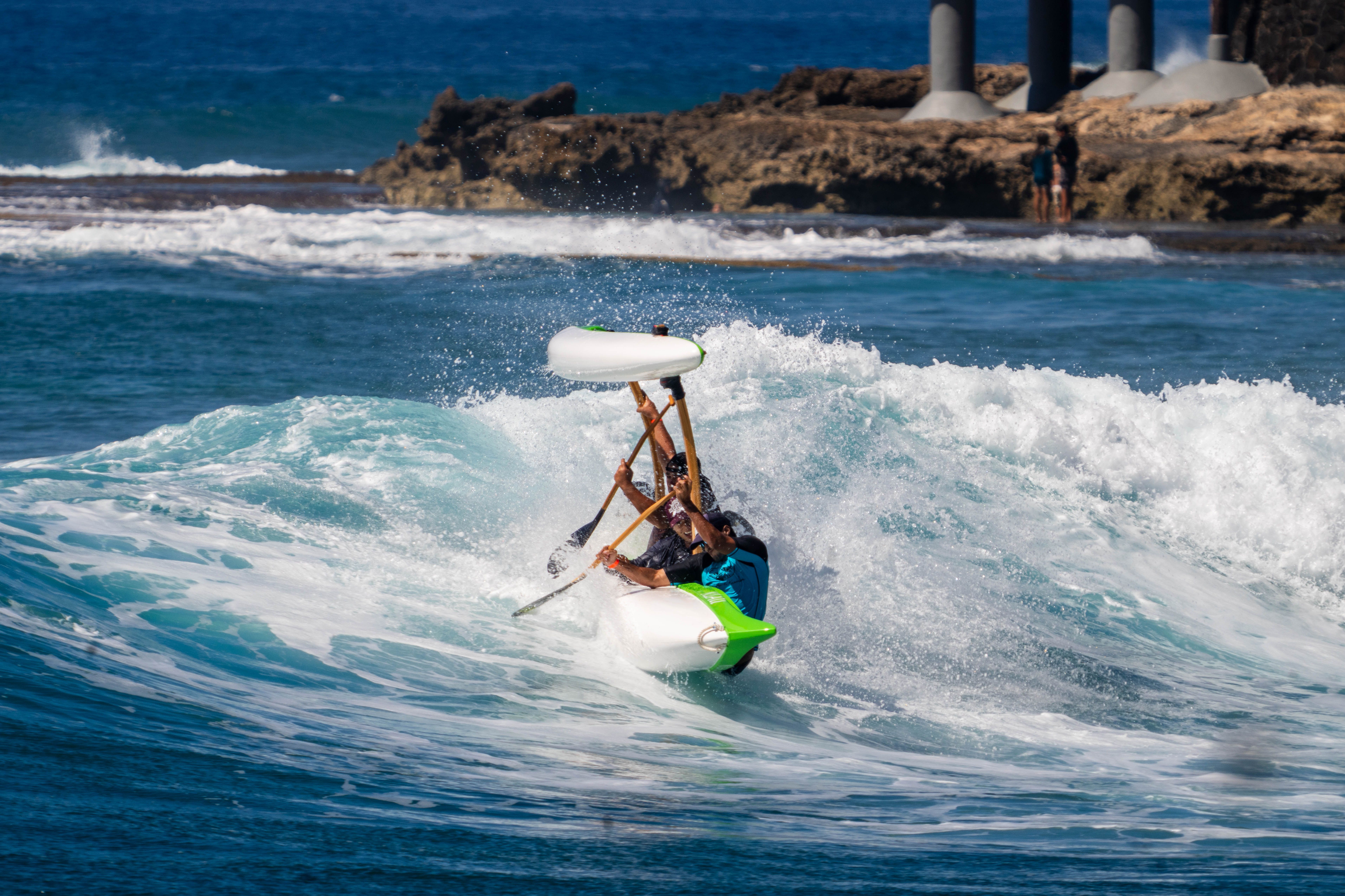 Exciting moment capturing outrigger canoe surfing on Hawaiian waves.
