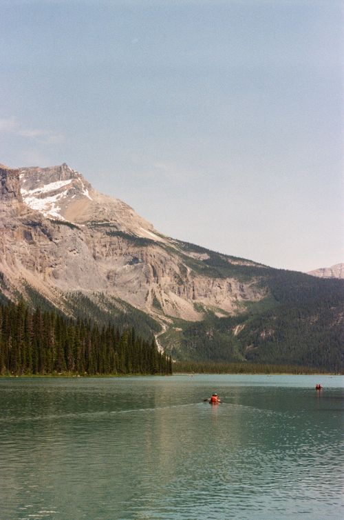 Free Scenic view of kayakers on Emerald Lake with mountains in Yoho National Park, Canada. Stock Photo