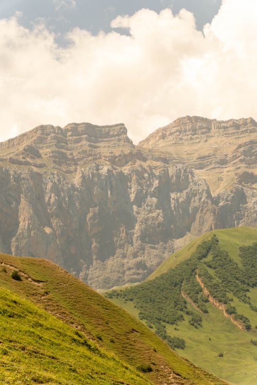 Free Stunning mountain range with lush green hills under a bright sky, captured in daylight. Stock Photo