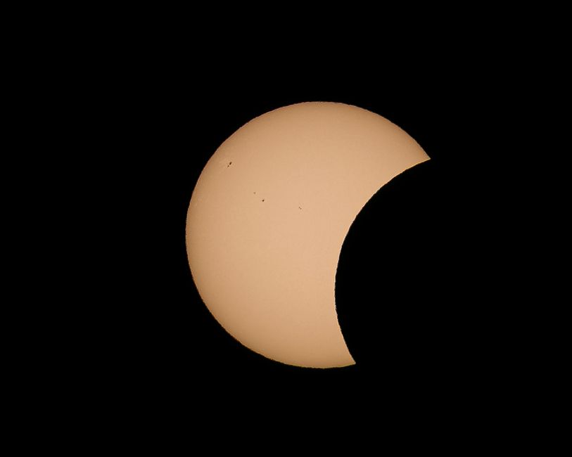 Fotomural Impresionante vista de un eclipse solar parcial capturada con gran nitidez contra un cielo negro y despejado.