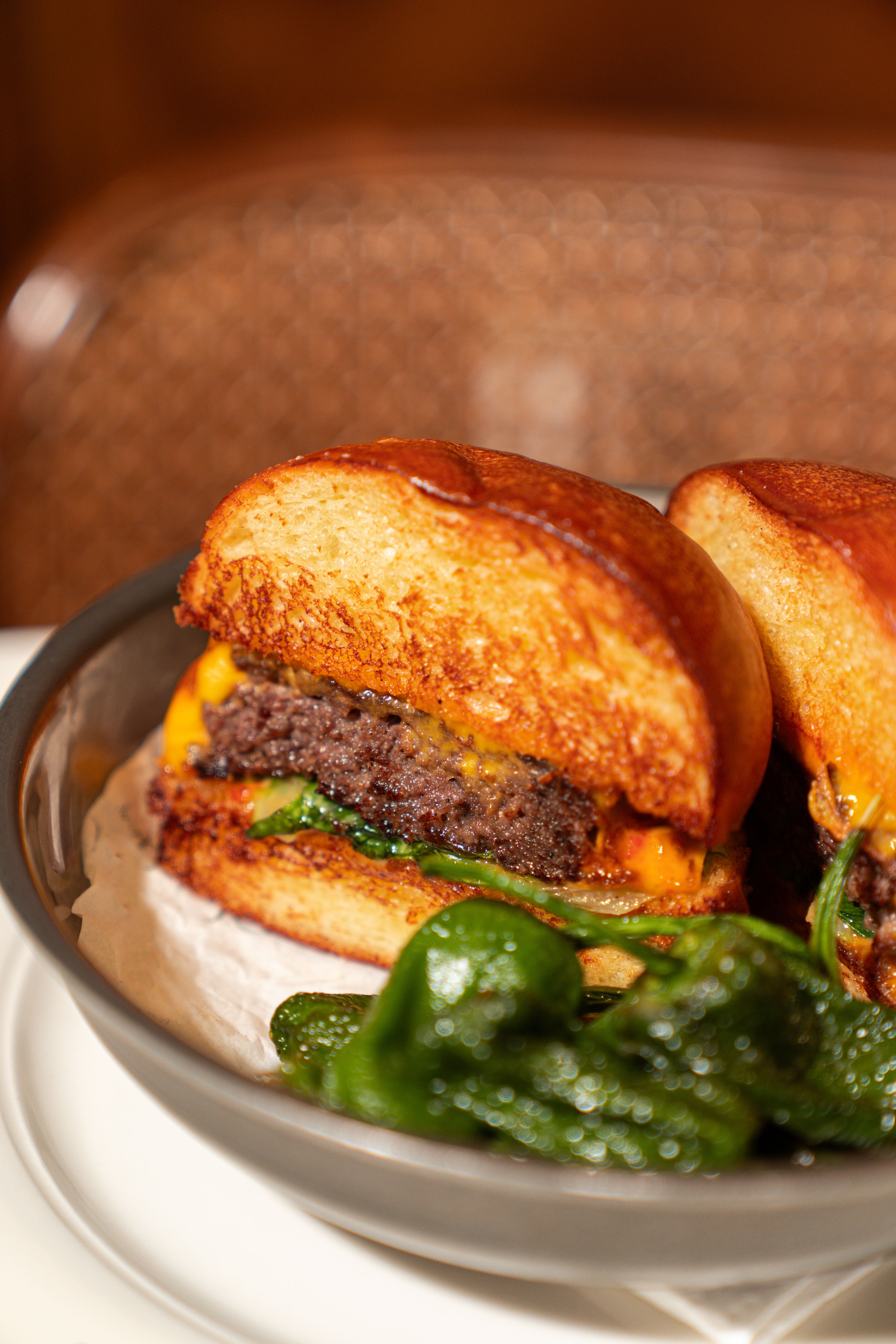 Close-up of a gourmet cheeseburger with fresh greens, perfect for enjoying a gourmet meal.