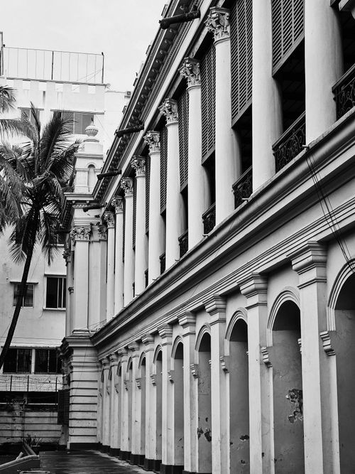 Free Black and white photo capturing historic colonial building with columns in an urban area. Stock Photo