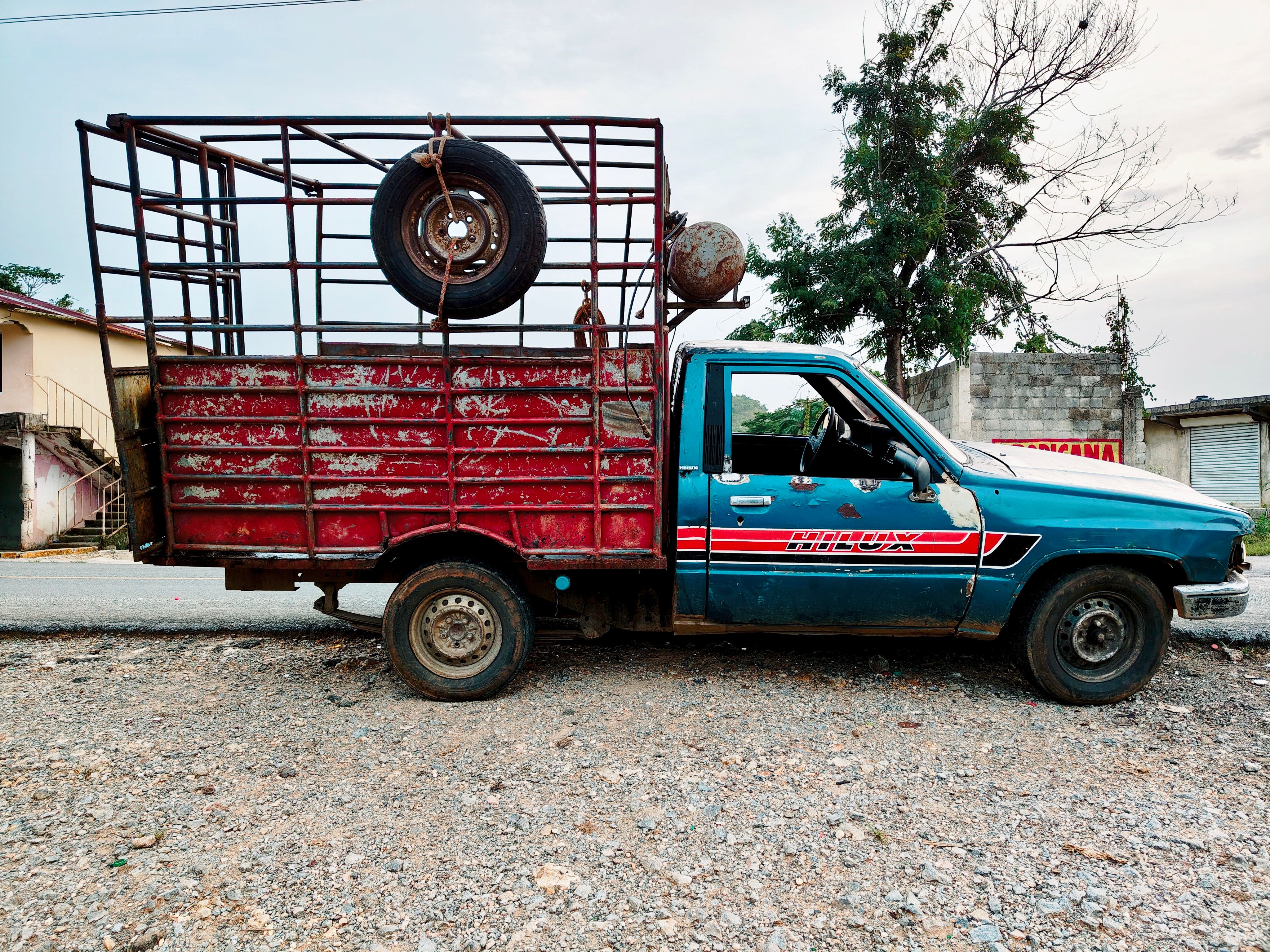 Pickup truck parked beside a farm workshop building awaiting a service