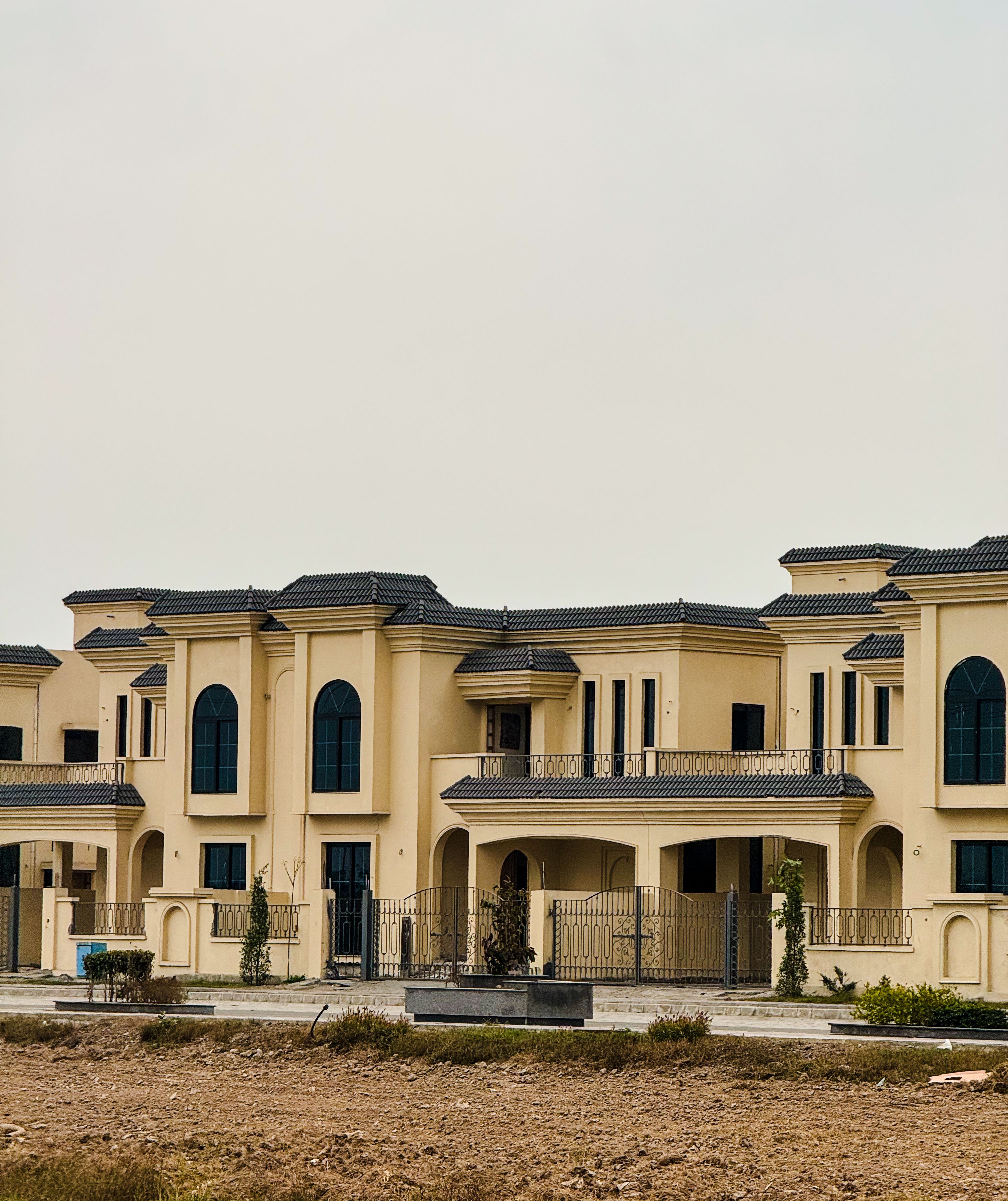 Spacious modern home with arched windows and a clean stucco facade, inviting buyers and sellers to start a conversation about Inspirada