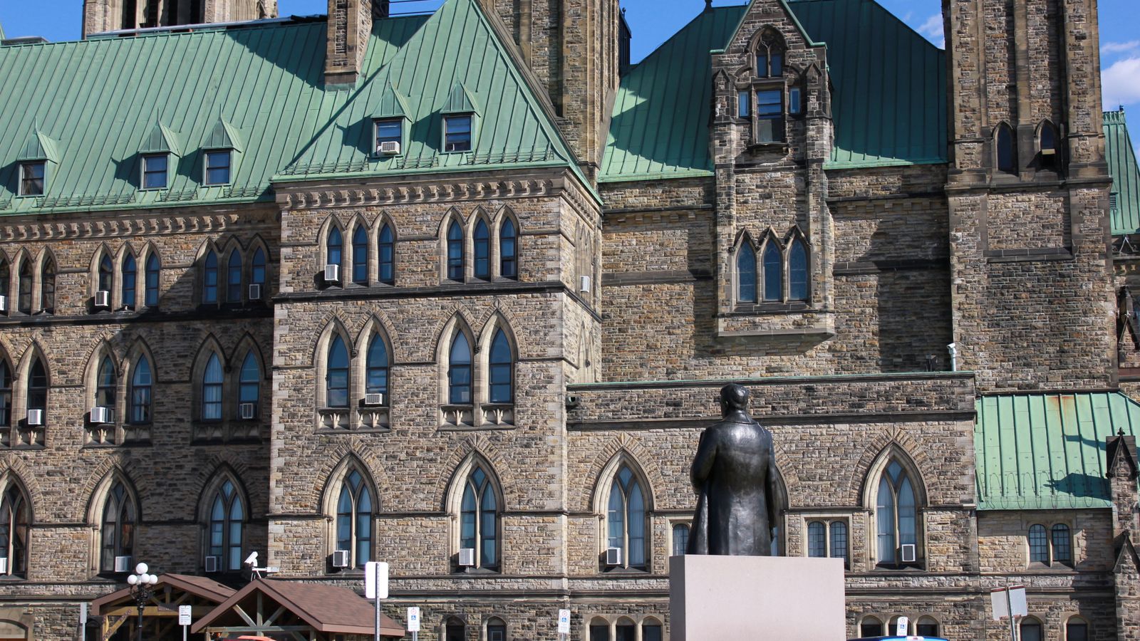 View of a historic Gothic Revival building with a statue in Ottawa, Canada.