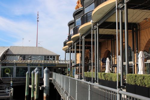 Free View of a modern harborfront building with balconies and visible harbor information center. Stock Photo