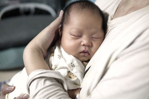 Free A serene scene of a baby sleeping peacefully in a parent's embrace, conveying warmth and safety. Stock Photo