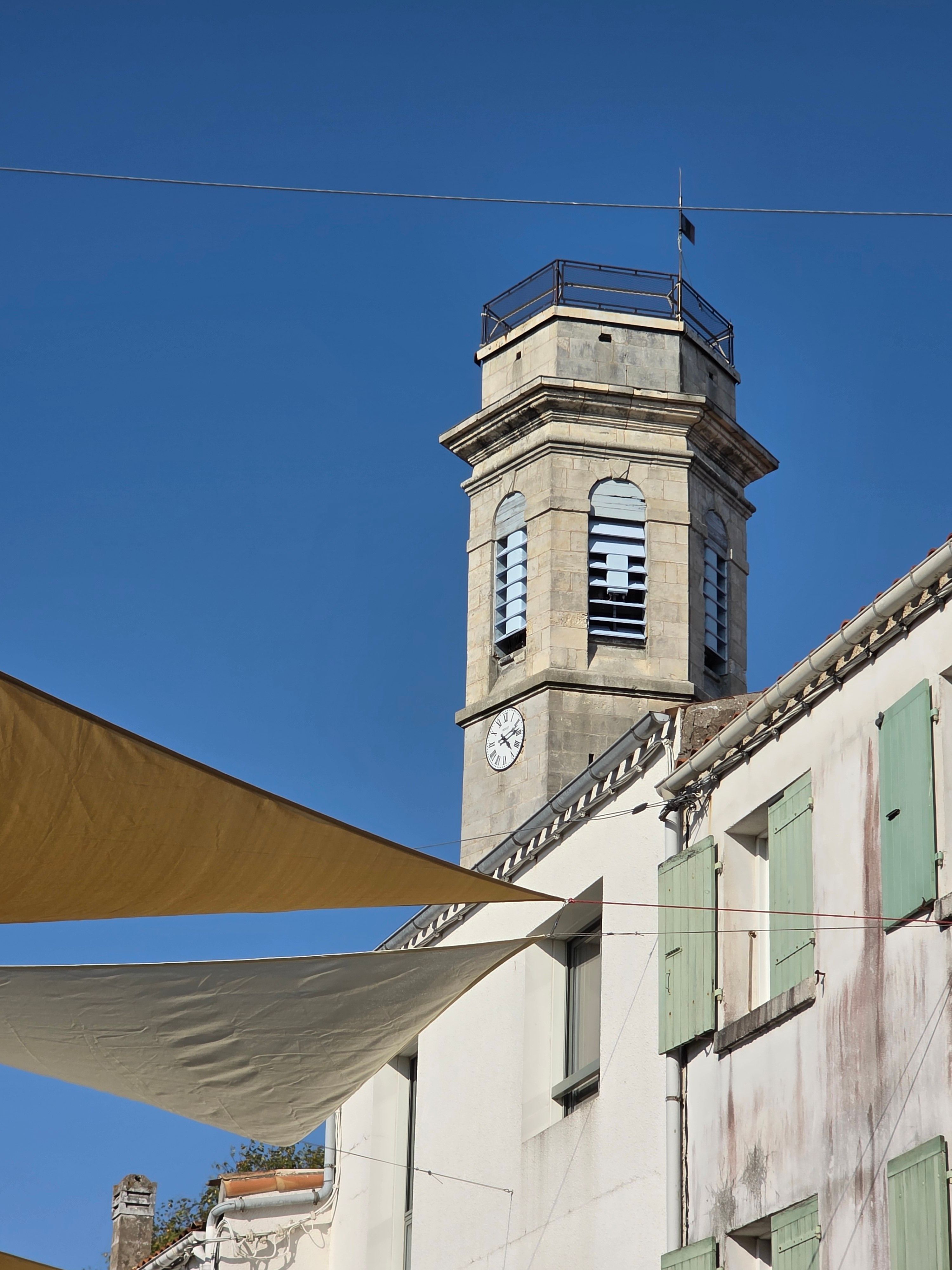 View of the historic clock tower against a clear sky in Saint-Pierre-d'Oléron, France.