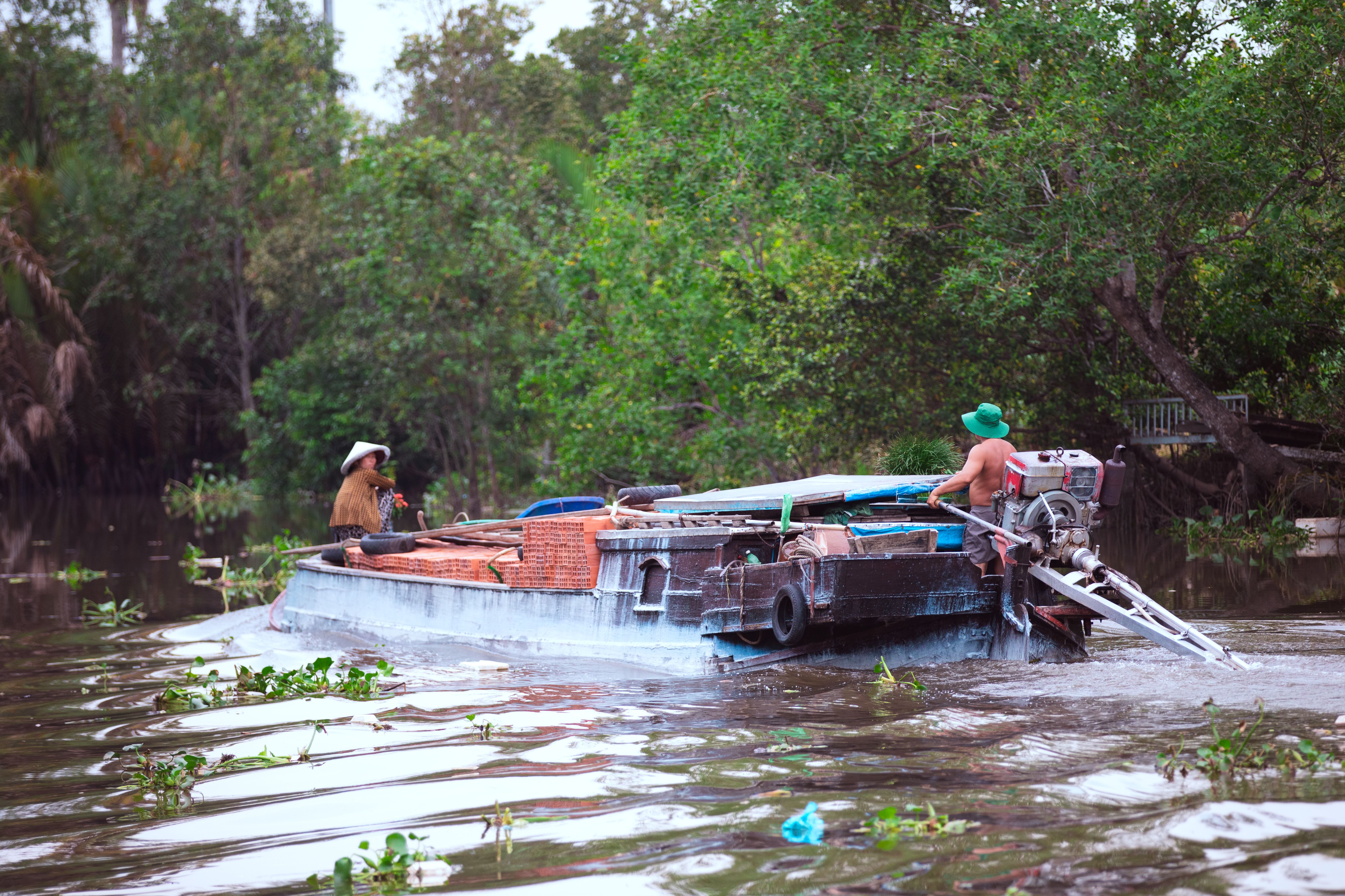 Barca navegando por un canal estrecho del Delta del Mekong en Can Tho